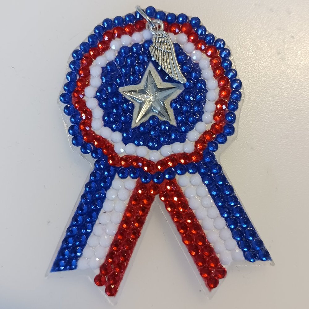 Ribbon magnet with metal wing charm